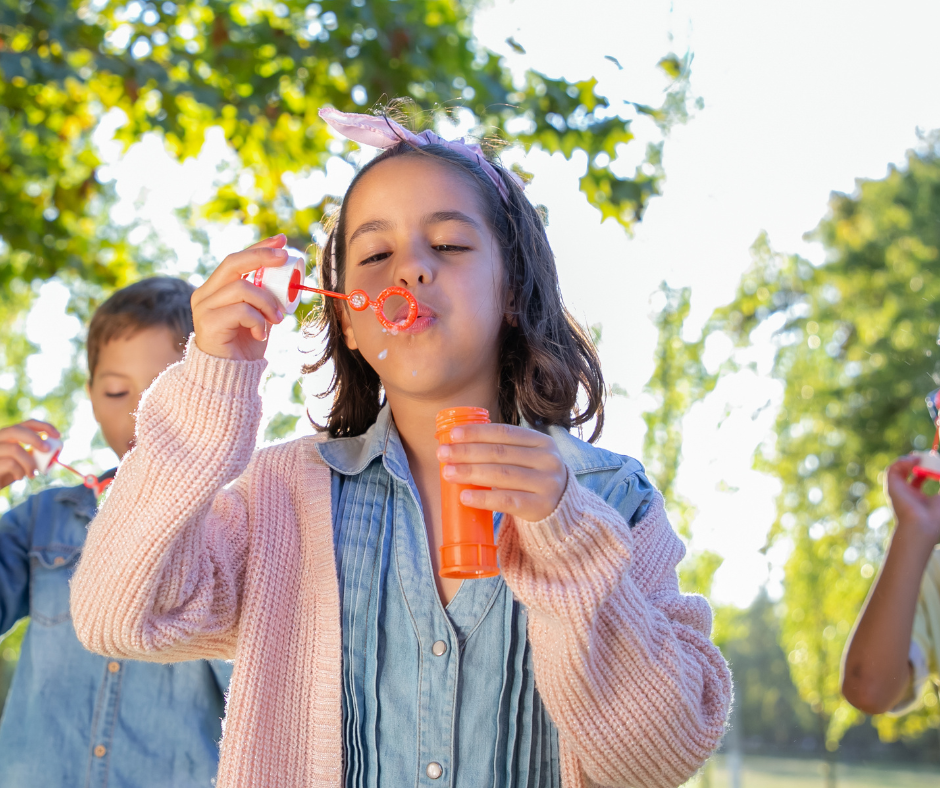 2 Kinder beim Seifenblasen im Park